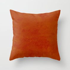 an orange pillow on a white wall