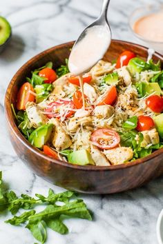 a wooden bowl filled with salad and dressing