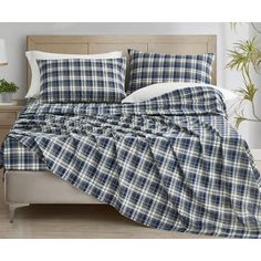 a bed with blue and white plaid sheets