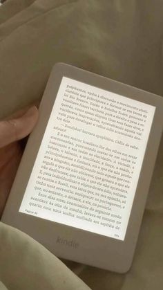 someone is reading a kindle book in bed with their hand on the back cover