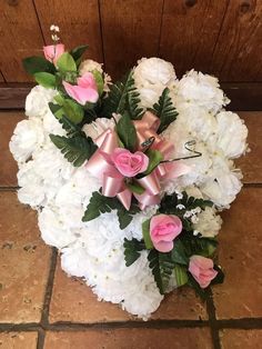 a bouquet of white and pink flowers on a tile floor