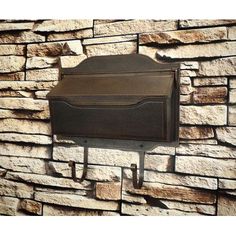 a mailbox mounted to the side of a stone wall