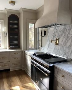 a kitchen with marble counter tops and an oven in the center, along with wooden flooring