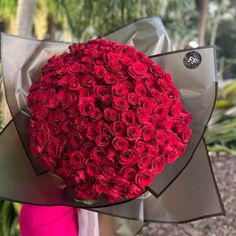 a woman holding a bouquet of red roses