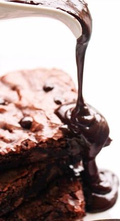 a piece of chocolate cake is being drizzled with melted chocolate on top