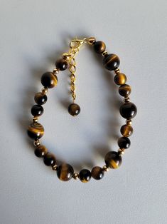 "Tiger Eye gemstones come in several colors. All of which have a sheen or silky luster like the shine in the eyes of a tiger from which it gets it's name. This bracelet features Yellow Tiger Eye (classic) beads and gold-plated brass beads and findings. The bracelet has a 1\" extension with a beaded drop making it adjustable. This gemstone is believed to provide the wearer with strength, courage, protection, willpower, improves  self-confidence, and brings balance to life. Custom Orders are alway Tiger's Eye Bracelet, Tigers Eye Bracelet, Tiger Eye Jewelry, Yellow Gemstones, Bracelets Design, Tiger Eye Bracelet, Crystal Healing Bracelets, Tigers Eye Gemstone, Tiger Eye Beads