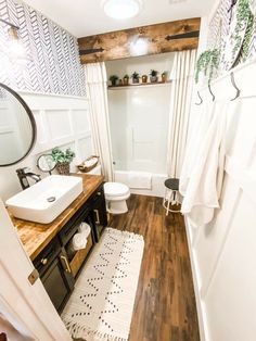 a bathroom with wood floors and white walls