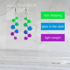 From day to night, these glow-in-the-dark earrings add a touch of elegance to every moment. Stand out with our exquisite earrings that glow der black lights and look stunning in the daylight. Perfect for night time outings, and glow parties these delicate resin earrings look fantastic during the day as well as in the dark. Green, blue and purple facets provide neon colors in the light, BUT shine a black light on these earrings and they'll give off a radiant glow.  They are lightweight and ideal Green Halloween Party Earrings, Glow In The Dark Earrings, Halloween Party Accessories, Dark Earrings, Dark Green Blue, Spooky Chic, Black Lights, Welcome Home Gifts, Artistic Wire