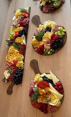 a table topped with lots of different types of fruit and cheeses on top of wooden plates