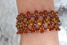 a woman's arm is adorned with bracelets made of beads and glass beads