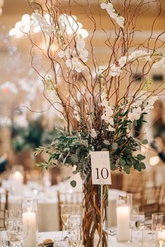 a centerpiece with flowers and candles on a table