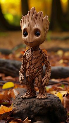 a baby groote figurine sitting on top of a pile of leaves