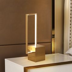 a lamp that is sitting on top of a table in front of a mirror and bed