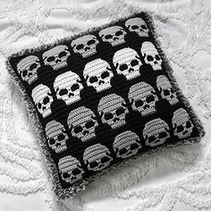 a crocheted pillow with skulls on it