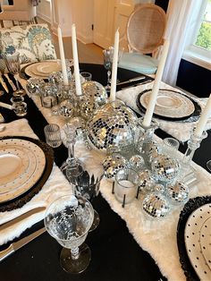 a black table topped with lots of dishes and silverware covered in disco ball decorations