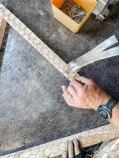 a man holding a baseball bat next to a chicken wire fence with other items in the background