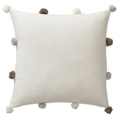 a white pillow with pom - poms on the front and back of it