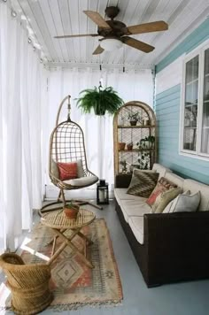 a porch with two hanging chairs and a hammock on the floor next to a window