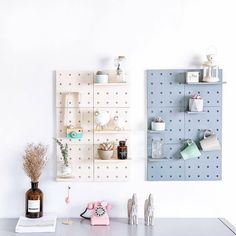 a white wall with shelves and vases on it next to a shelf filled with items