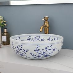 a blue and white bowl sink sitting on top of a counter next to a faucet