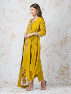 Asymmetric wrap style kurta is embellished with contrasting pink beadwork. It is paired with sequins highlighted dupatta and glace cotton elasticated pants detailed woth lace. Color: Mustard Yellow Fabric: Chanderi, Georgette and glace cotton Note: Wash Care - Dry Clean only The product will be delivered within 3-4 weeks of order placed Relaxed Fit Chanderi Anarkali, Asymmetric Kurta, Mustard Fabric, Zardozi Work, Kurta Set For Women, Smart Outfit, Pants Details, How To Hem Pants, World Of Art