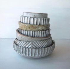 three bowls stacked on top of each other in front of a white wall and floor