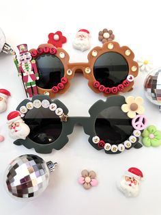 "CHRISTMAS SUNNIES!! These are so adorable-- Each pair is handcrafted by me. Using various beads, Charms, Rhinestones, and fun details! ♥️💚 *2 options available-- Choose your style:  1. LETS GET CRACKIN 2. GROOVY AND BRIGHT * Anti-Glare * UV Protection (UVA & UVB) * Durable and shatterproof  * They open and close smoothly  * Each item is made to order and will be ready to ship in 5-7 business days! If you need your order sooner. Please check out my \"RUSH ORDER OPTION\".  https://www.etsy.com/EyeCandyandFluff/listing/1286351273/rush-my-order-please *SHOP DISCLAIMER/WAIVER!  * Do NOT let your child put the sunglasses in their mouth as beads can become detached.    Always monitor and supervise while children are wearing these. The shop assumes no responsibility for sunglasses made. Sizing-- Fun Handmade Sunglasses As A Gift, Fun Handmade Sunglasses For Parties, Fun Handmade Sunglasses For Party, Trendy Handmade Sunglasses For Gift, Trendy Handmade Sunglasses As A Gift, Trendy Handmade Sunglasses Perfect As A Gift, Handmade Fun Plastic Sunglasses, Handmade Plastic Fun Sunglasses, Trendy Handmade Sunglasses As Gift