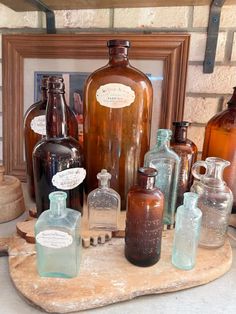 old glass bottles are sitting on a wooden tray