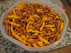 a plastic container filled with cheetos sitting on top of a counter