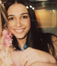 two young women are smiling and posing for a photo with flowers in their hair,