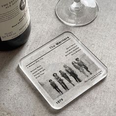 a bottle of wine sitting next to a glass on top of a marble countertop