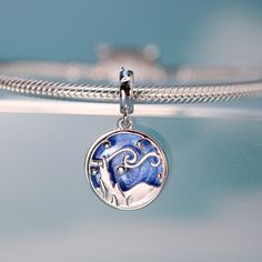 This is charm only, bracelets are sold separately. Experience the allure of Van Gogh's iconic "Starry Night" every day with this exquisite dangle charm. Featuring a stunning blue sky and a silhouette landscape design, this charm is the perfect addition to any bracelet or gift for a loved one. Don't miss out on the chance to own this unique piece inspired by one of the most famous paintings in the world! Materials: 925 sterling silverFinish: platinum plate, enamelDimensions: 0.85 x 0.51 inHole size: 0.18 in Jewelry Care: See more information about how to care for your jewelry here. Shipping Policy: Orders will be shipped within 1-3 business days. Economy shipping will take 7-14 days to arrive and standard shipping is 1- 4 days for U.S. orders. International shipping time is depended on the Sterling Silver Jewelry Pendant With Star Charm, Celestial Sterling Silver Charms Jewelry, Silver Moon Charm Pendant, Silver Dangle Moon Charm, Sterling Silver Charm Necklace With Removable Charms, Sterling Silver Charm Necklaces With Removable Charms, Celestial Silver Jewelry With Charms, Celestial White Gold Jewelry With Charms, Blue Sterling Silver Charm Necklace With Lobster Clasp