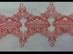 red and white embroidered fabric with small squares on the side, in an intricate pattern