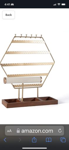 a gold and white display case on top of a wooden stand with an amazon logo above it