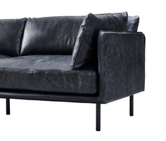 a black leather couch with two pillows on it