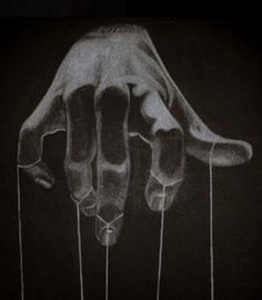 a drawing of a hand reaching out from the ground, with strings attached to it