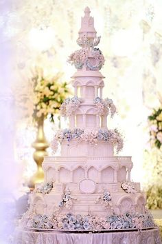 a white wedding cake with blue flowers on top