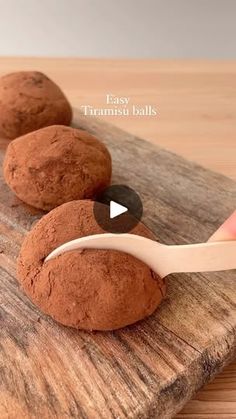 a person using a spoon to scoop out some kind of chocolate treat on a cutting board