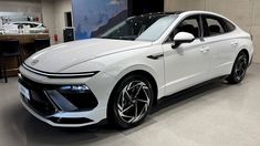 a white car is on display in a showroom