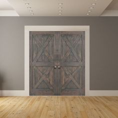 an empty room with two wooden doors on the wall and wood flooring in front of it