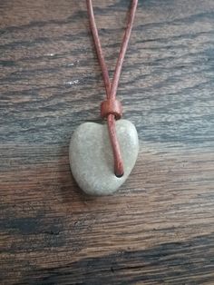 a heart shaped rock on a leather cord