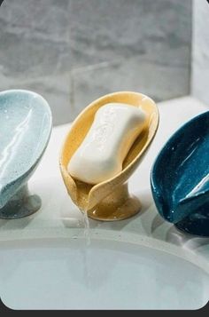 three ceramic bowls sitting on top of a sink