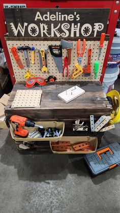 a workbench with tools on it sitting in front of a sign