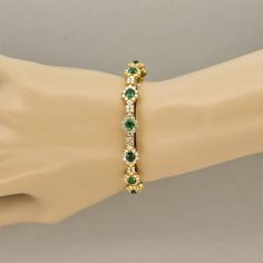 A stylish bangle bracelet featuring oval shaped emeralds weighing a total of 4 carats. They are accented by 5.00 carats of round brilliant cut diamonds set in a lovely pattern around the entirety of the bangle. Made in 22k yellow gold and ready to be worn!    Circumference: 8 inches    Weight: 22.6 grams Green Bangle Tennis Bracelet For Anniversary, Green Diamond Round Bracelet, Green Oval Diamond Tennis Bracelet, Elegant Oval Green Bangle, Elegant Gold Bangle With Emerald, Diamond And Emerald Bangles, Green Oval Diamond Bracelets, Oval Green Diamond Bracelets, Elegant Green Oval Bangle