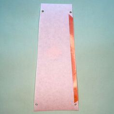 a piece of pink paper with an orange strip on it