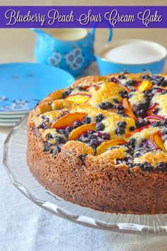 a blueberry peach sour cream cake on a glass platter