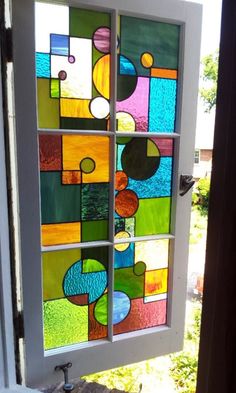 a glass window with different colors and shapes on the side of it in front of a door