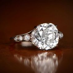 an old - fashioned diamond ring is displayed on a table