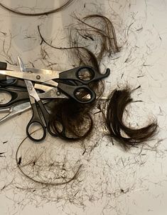 scissors are laying on top of some hair