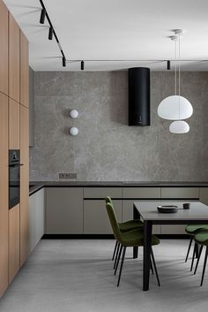 a dining room table with green chairs next to an oven and cabinets in the background